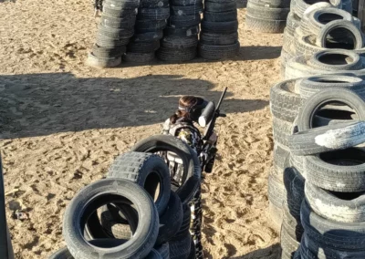 Paintball shooter behind wall of tyres